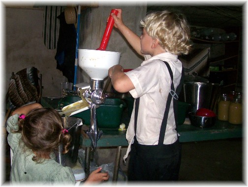 Amish children making apple sauce