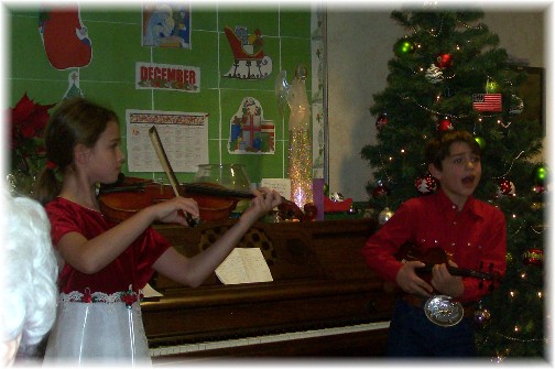 Children playing violins at the Messiah Village Christmas party 2011