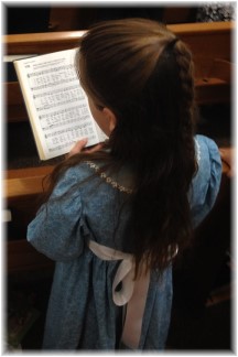 Child singing from hymnal
