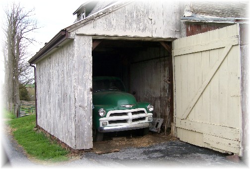 Green truck in barn