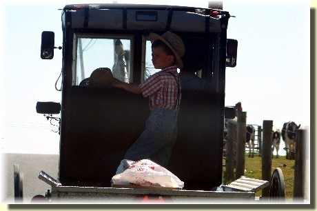 Old order Mennonite boy riding in pickup