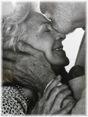 Elderly man kissing woman on forehead