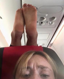 Feet on back of plane seat